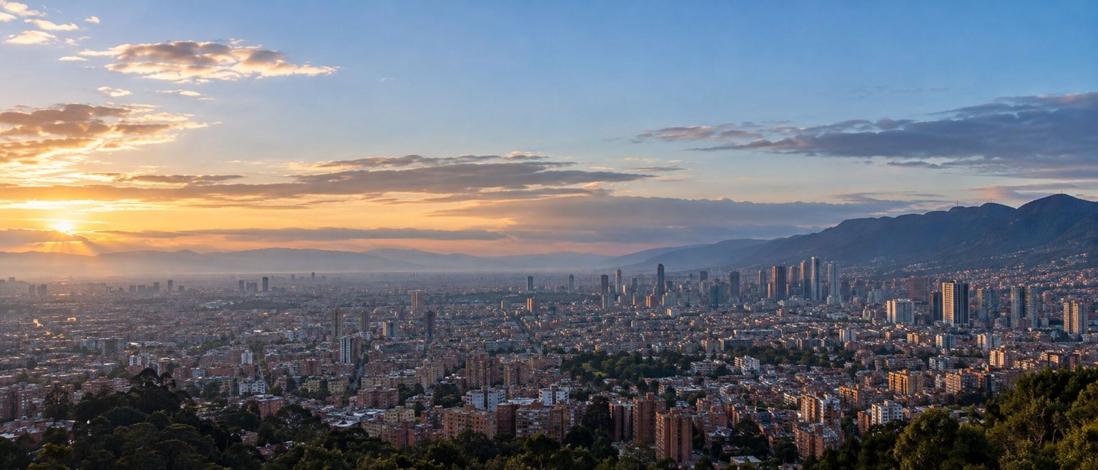 Amanecer sobre una ciudad andina colombiana, luz cálida entrando sobre los cerros